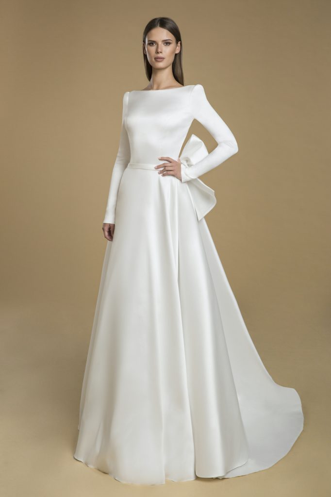 Full coverage winter wedding dress with high neckline across the collarbone, long sleeves and giant box in the back. 